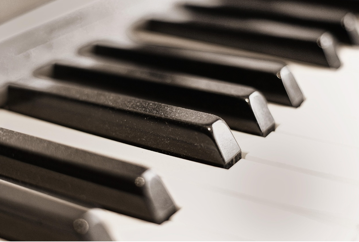 Afbeelding met pianotoetsen.